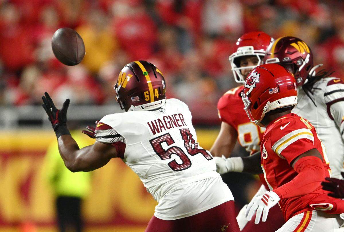 Washington Commanders linebacker Bobby Wagner (54) intercepts a pass after it bounced off intended receiver Kansas City Chiefs tight end Travis Kelce (87) in the first quarter on Monday, Oct. 27, 2025, at GEHA Field at Arrowhead Stadium.