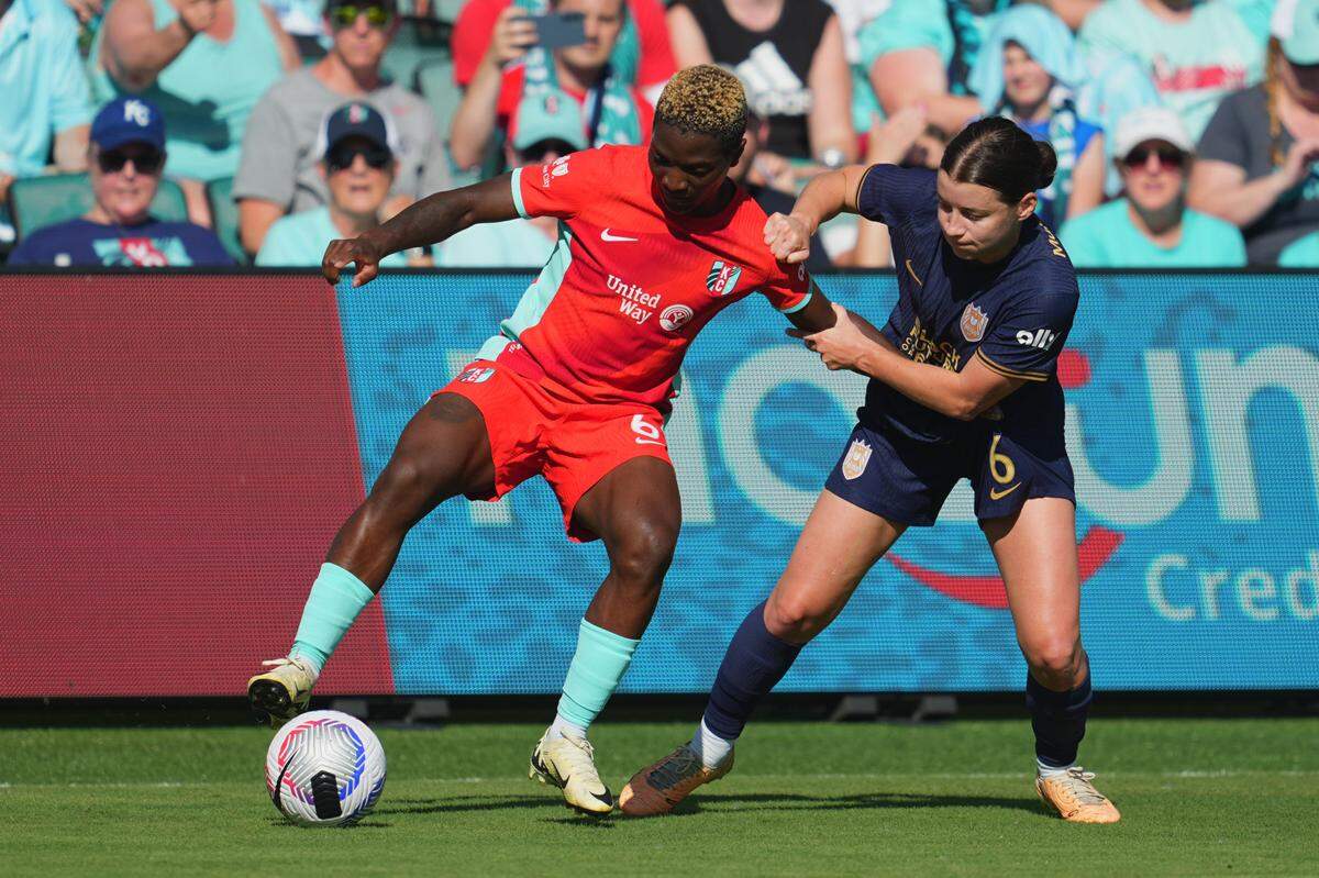 Kansas City Current forward Temwa Chawinga, left, plays the ball against Seattle Reign midfielder Angharad James during Sunday’s match at CPKC Stadium.