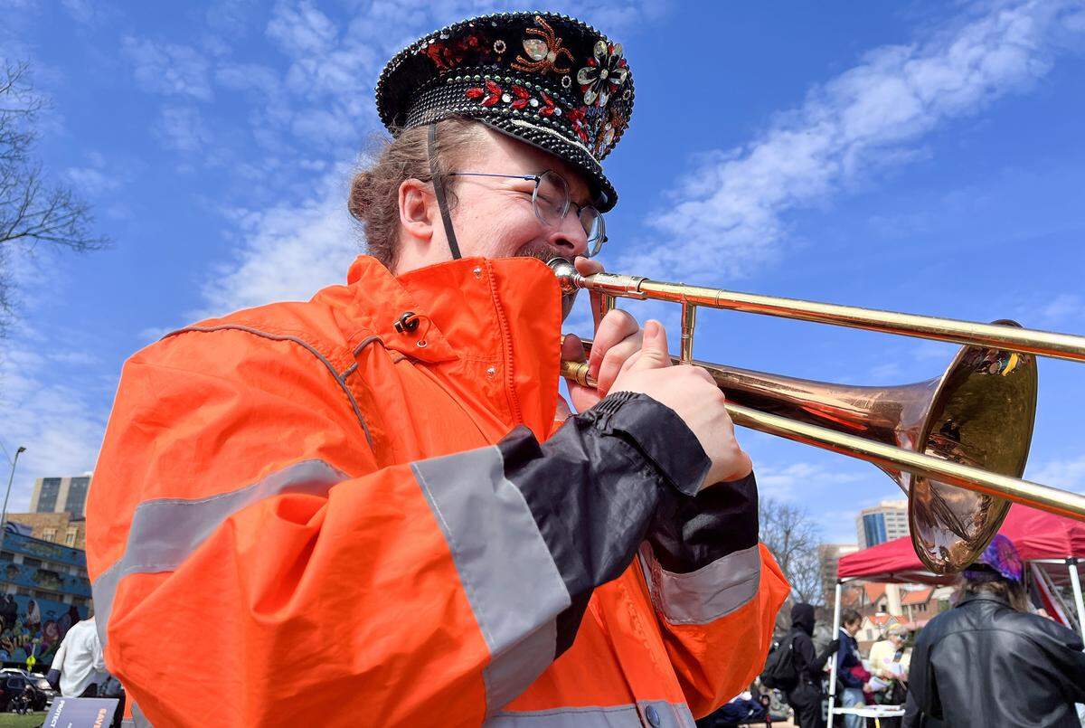Aster Clark plays a trombone during a No Kings protest against the Trump administration in Mill Creek Park near the Country Club Plaza on Saturday, March 28, 2026, in Kansas City.
