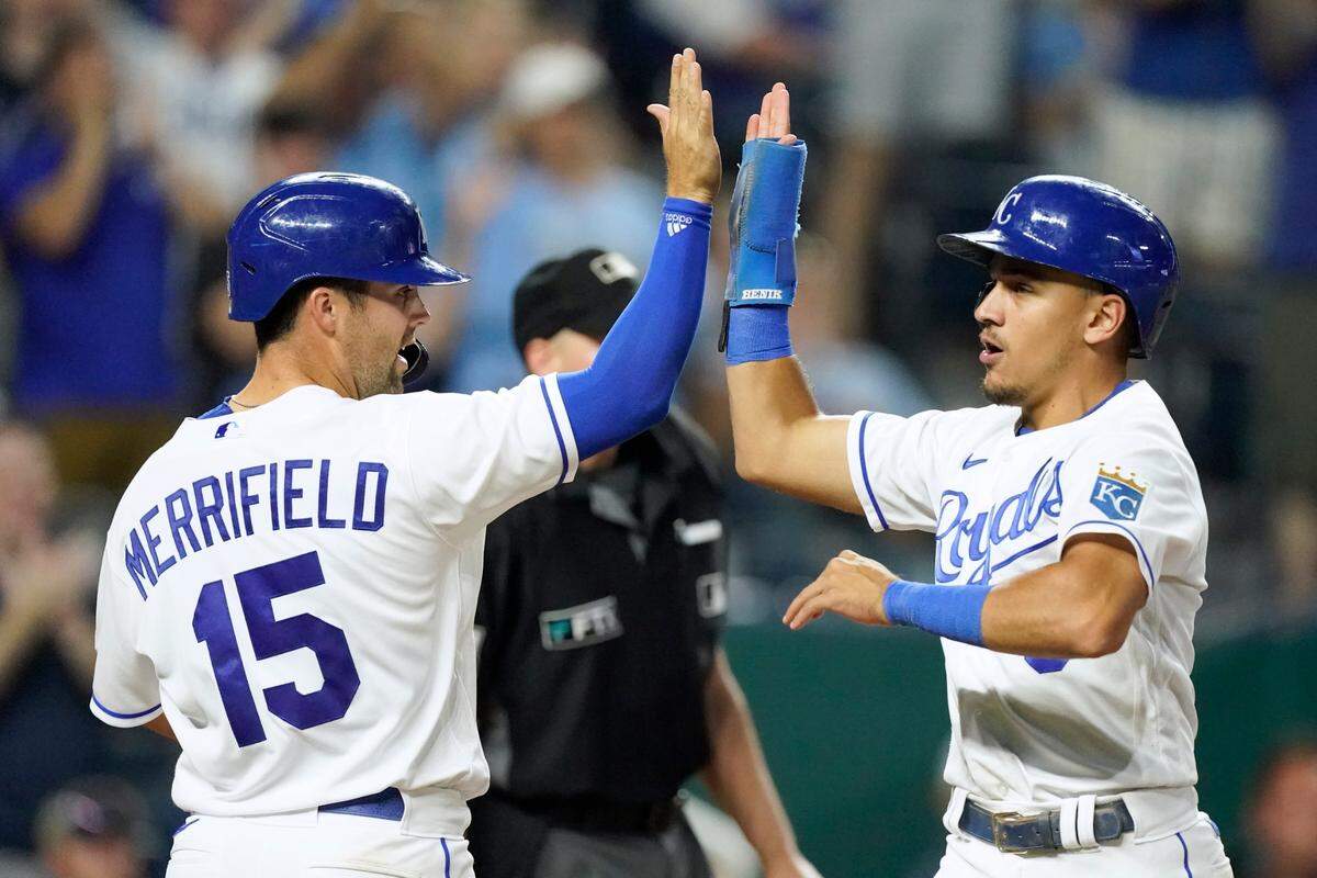 Kansas City Royals’ Whit Merrifield (15) and Nicky Lopez celebrate after scoring on a two-run single hit by Salvador Perez during the eighth inning of a baseball game against the Houston Astros Monday, Aug. 16, 2021, in Kansas City, Mo. (AP Photo/Charlie Riedel)