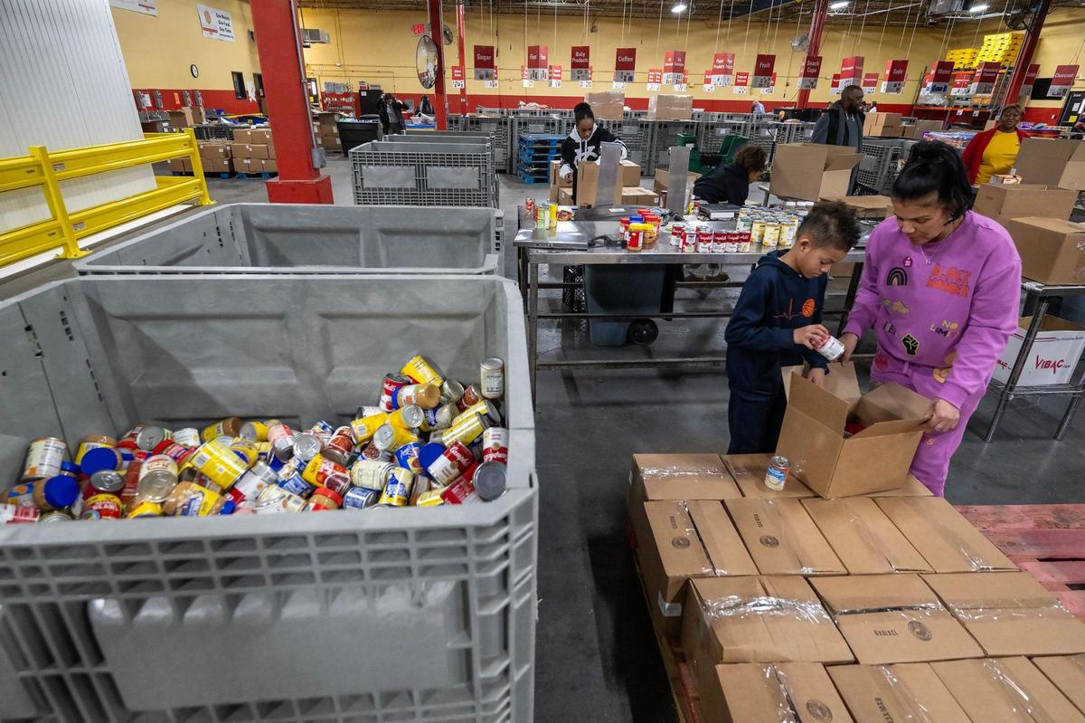 Volunteers Nancy Allen and her son, Maxwell Simmons, 9, of Lee’s Summit, pack protein boxes at Harvesters on the MLK Day of Service on Monday, Jan. 20, 2025, in Kansas City. Harvesters is a community food network that distributes food and resources through more than 900 partner agencies.