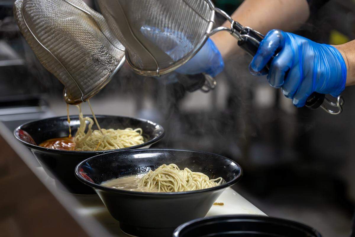 Kenichi Ota, owner of KC Craft Ramen, pours ramen noddles into a bowl as he prepares an order on Wednesday, Oct. 29, 2025, in Overland Park.