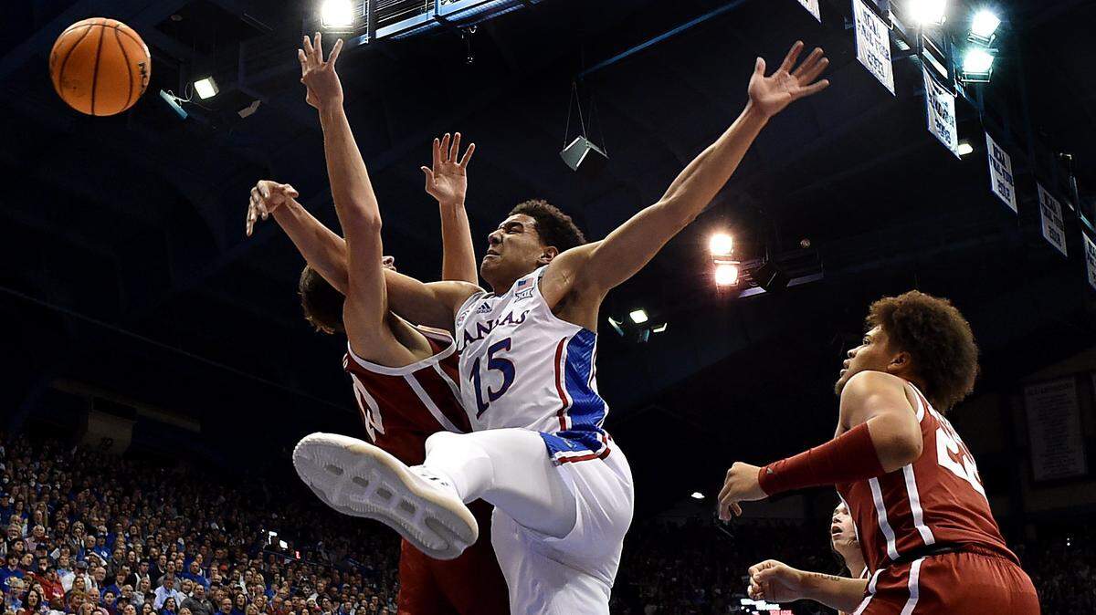 KU’s Kevin McCullar gets tangled up with OU’s Sam Godwin while battling for a rebound during the first half of a Big 12 Conference game at Allen Fieldhouse.