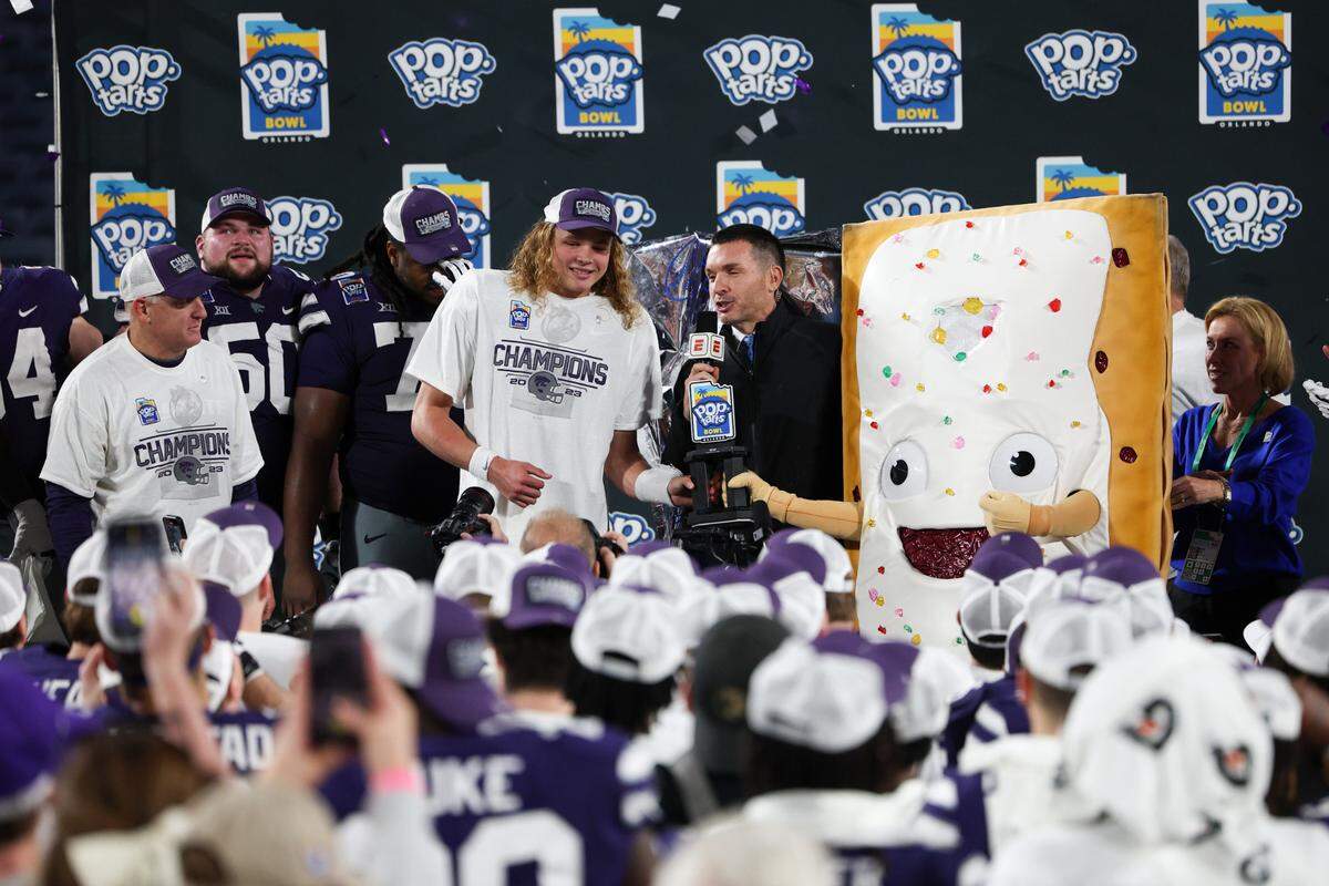 K-State football players celebrate with the Pop-Tarts Bowl mascot after a win over NC State at Camping World Stadium in Orlando on Dec. 28, 2023.