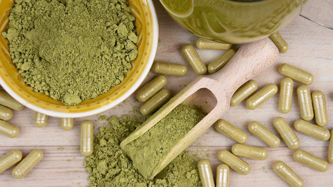 Green kratom powder, capsule and beverage still life above stock photo. Kratom herbal medicine stock images