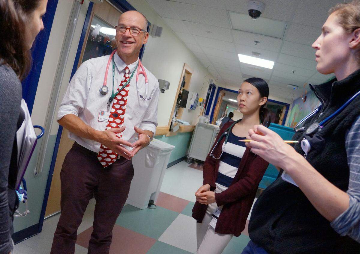 Dr. William Raszka, a pediatric infectious disease specialist at the University of Vermont’s Larner College of Medicine, shown here with students, says grade-schoolers are generally the safest group of students to return to classrooms right now.
