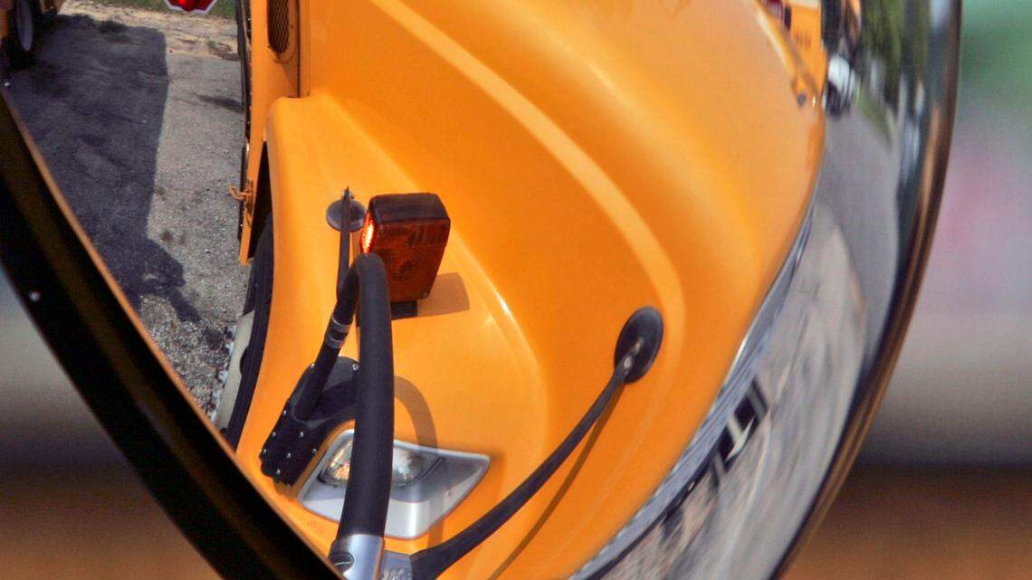 File photo of a school bus as its stop sign is reflected through the mirror. An 8-year-old student in Missouri was struck by a driver illegally passing a school bus as its lights were on and stop sign was out, officials said.
