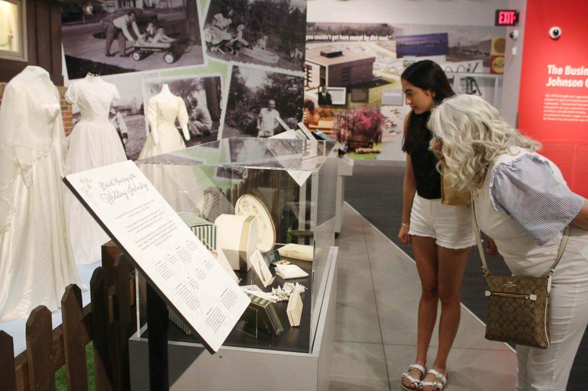 Overland Park residents Karina Canales and Romina Martinez look at some of the wedding dresses and accessories outside the All-Electric House at the Johnson County Museum this past June.