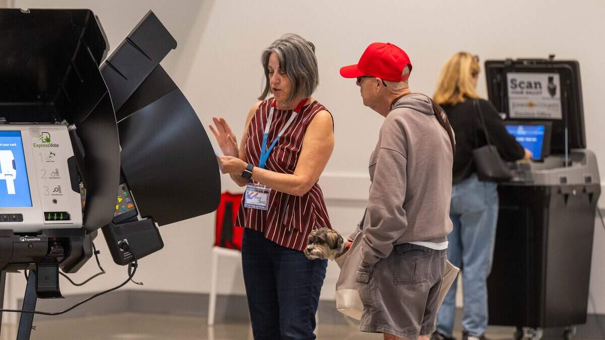 Mary Jane Suppasansathorn assists a voter on Election Day, Tuesday, Nov. 4, 2025, at Johnson County Arts and Heritage Center in Overland Park.