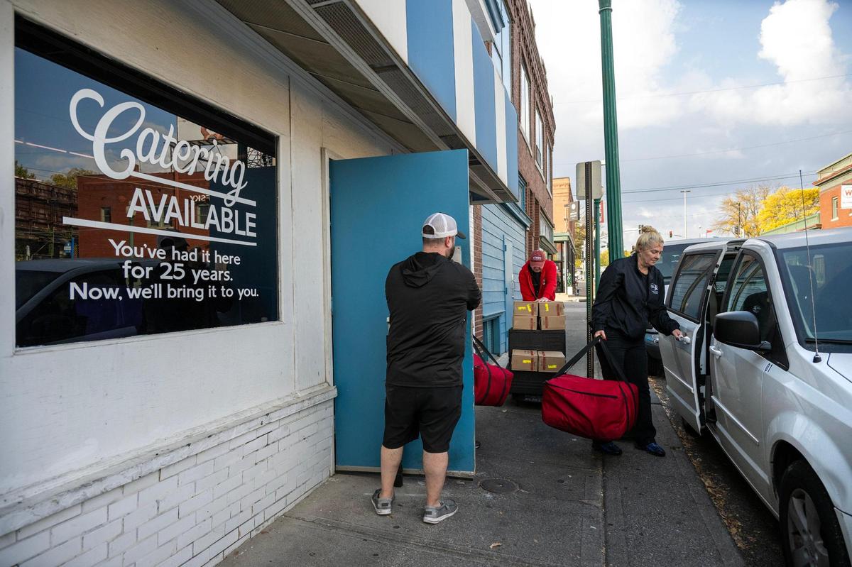 Each morning, 14 vans line the curb outside the Westport Flea Market to bring breakfast and later lunch to as many as 5,000 students, mostly in charter schools around Kansas City. Employees Travis Shklar, from left, Cole Kimball and Christina Ferchichi load up lunches before heading out.