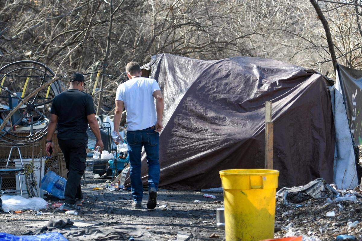 Josh Henges, Houseless Prevention Coordinator for Kansas City, approaches a tent used for shelter set up in a wooded area not far from Independence Avenue on Wednesday, March 2, 2022, in Kansas City. Henges and another houseless advocate, were conducting Point-in-Time (PIT), a count of sheltered and unsheltered people experiencing houselessness.