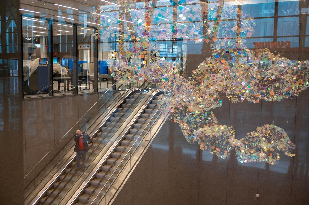 A test passenger takes photos of a sculpture called, “Molten Swing” by artist Son Sunny Park during a simulation tour at Kansas City International Airport on Tuesday, Feb. 14, 2023.
