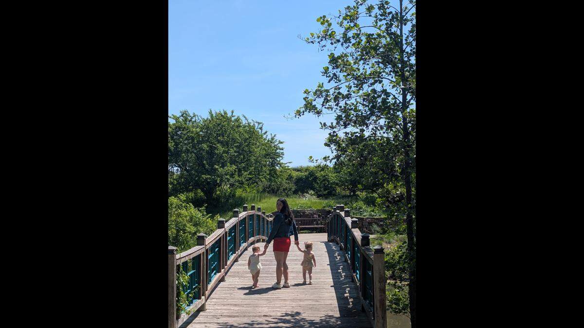 A photo of Ally Marshall walking with her two daughters.