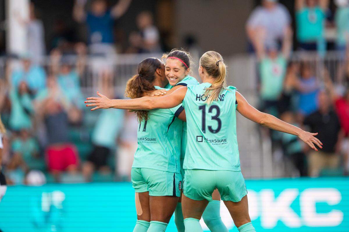 KC Current teammates celebrate the first pro soccer goal scored by Mary Long, facing camera, during a Tuesday, July 15, 2025 Teal Rising Cup match against SC Corinthians at CPKC Stadium in Kansas City.