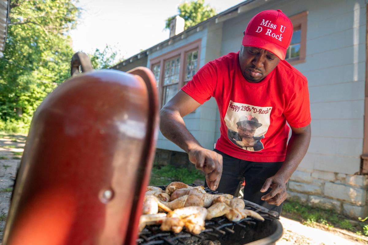 Antonio Hall cooks chicken on a grill that belonged to his nephew, Derrick Davis, on Aug. 9 at his sister’s home in the Oak Park neighborhood. The family’s regular Friday gatherings were disrupted when Davis was killed two years ago.