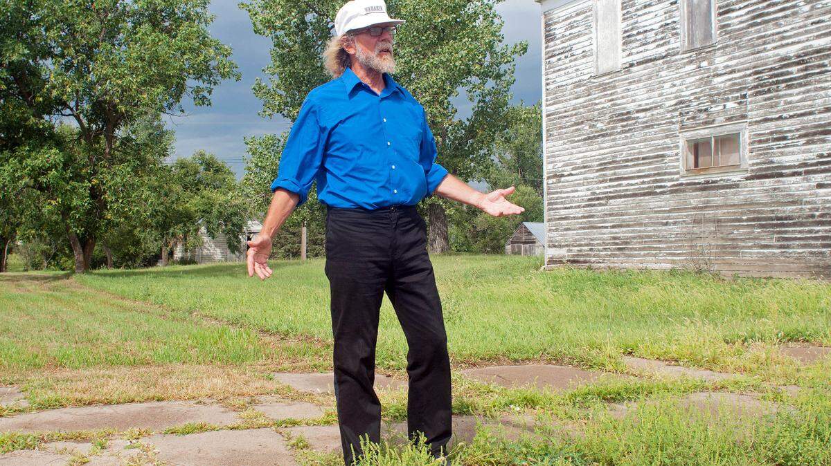 In this Aug. 26, 2013, photo Craig Cobb stands in an empty lot he owns on Main Street in Leith, N.D., where he envisions a park _ perhaps with a swimming pool _ dedicated to the late neo-Nazi and white supremacist activist William L. Pierce. Cobb, 61, a self-described white supremacist, has purchased about a dozen lots in Leith and over the past year he has invited fellow white supremacists to move there and help him to transform the town of 16 people into a white enclave.
