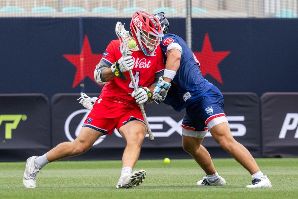 Dylan Molloy of Team West attempts to push past a Team East defender in the first quarter of the Lexus Men’s Lacrosse League All-Star Game at CPKC Stadium on Saturday, July 5, 2025.