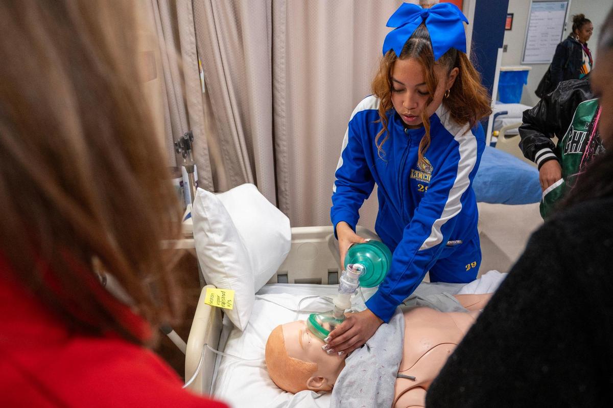 Kairos Im, 15, demonstrates her understanding of oxygen mask usage after receiving instruction during a hands-on training experience.