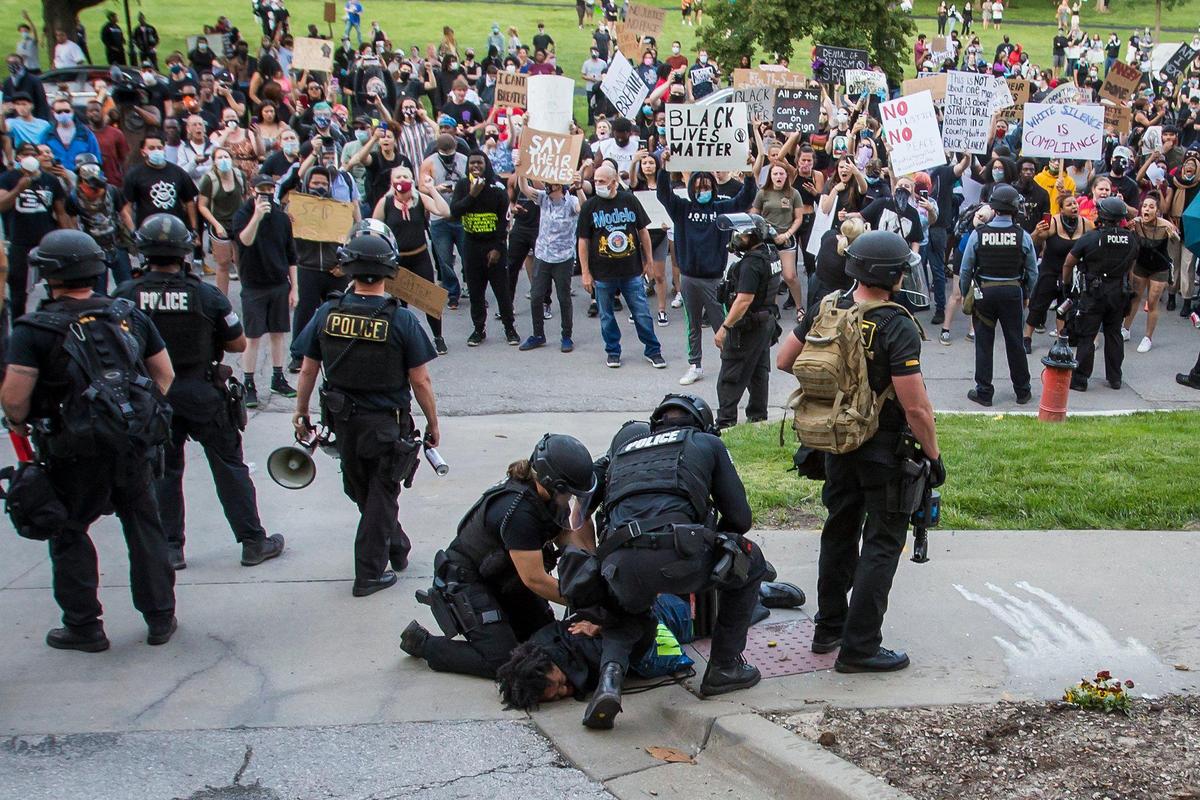 Kansas City police arrest a protester Saturday at the Country Club Plaza during a protest to bring awareness to the death of George Floyd who died in the custody of Minneapolis police. The protest turned violent later in the night when stores on the Plaza were vandalized and at least one police car was set on fire. Police used tear gas in an attempt to control the crowd.