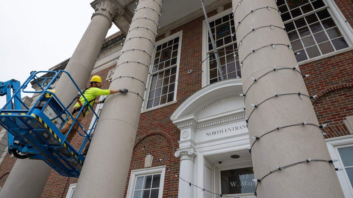 Electrical workers place Christmas decorations around the pillars of the Historic Truman Courthouse, Wednesday, July 3, in downtown Independence. The downtown area was being prepared to appear in scenes for a Hallmark Christmas movie that will be filmed there. The movie is based on a story around the Kansas City Chiefs.
