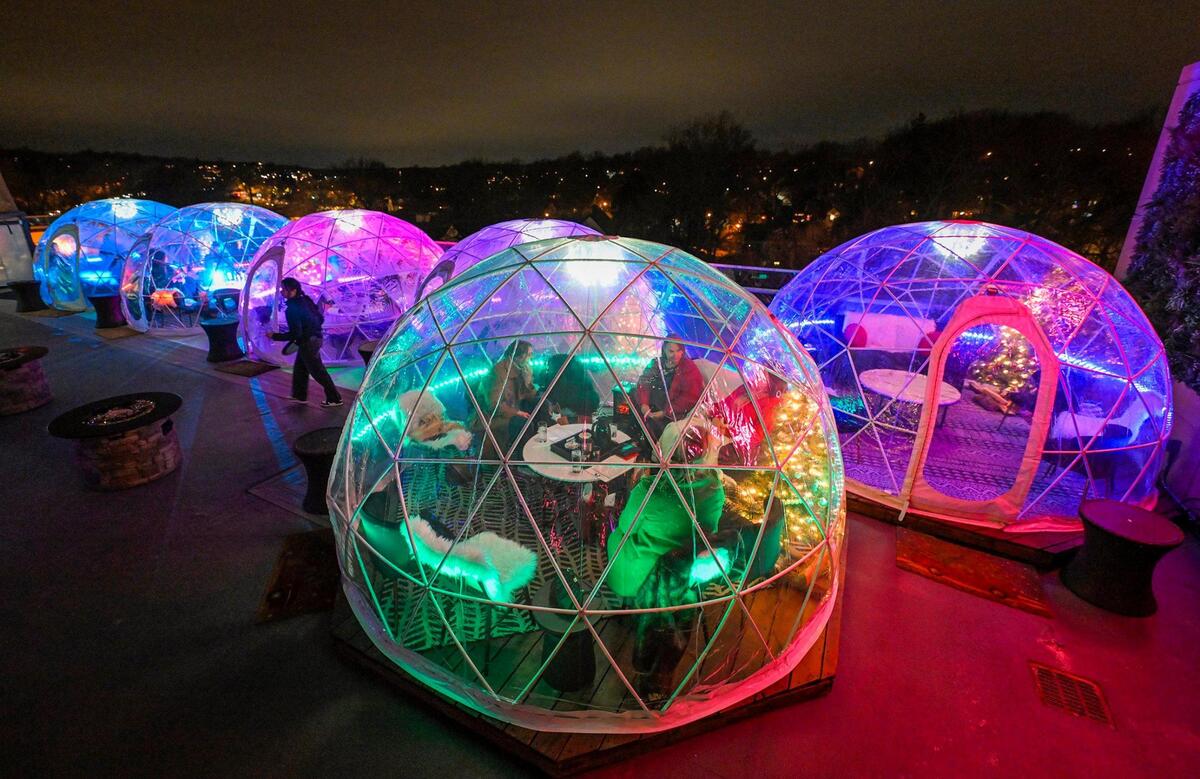 Server Travis Jones steps out of a holiday-decorated igloo where guests were tucked inside with cocktails and appetizers on Dec. 15 at Nine Zero One Igloo Bar & Lounge on the rooftop at The Fontaine, a hotel on the Country Club Plaza.