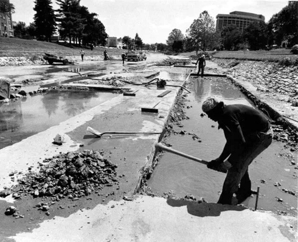 A 1978 photo shows a worker breaking up concrete on Brush Creek after flooding damaged the creekbed.