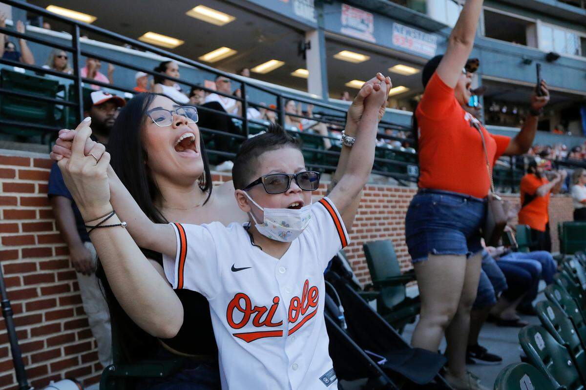 Karla Lopez, left, wife of Baltimore Orioles relief pitcher Jorge Lopez, reacts with their son Mikael Lopez, 9, as Jorge Lopez pitched out of a bases loaded jam against the Cleveland Guardians during the eighth inning of a baseball game, Saturday, June 4, 2022, in Baltimore. Lopez stayed in the game and recorded the save as the Orioles won 5-4. (AP Photo/Julio Cortez)