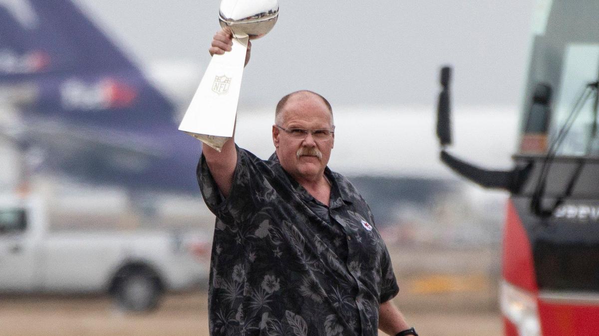 Kansas City Chiefs coach Andy Reid holds up the Lombardi Trophy after a plane carrying the team arrived at Kansas City International.