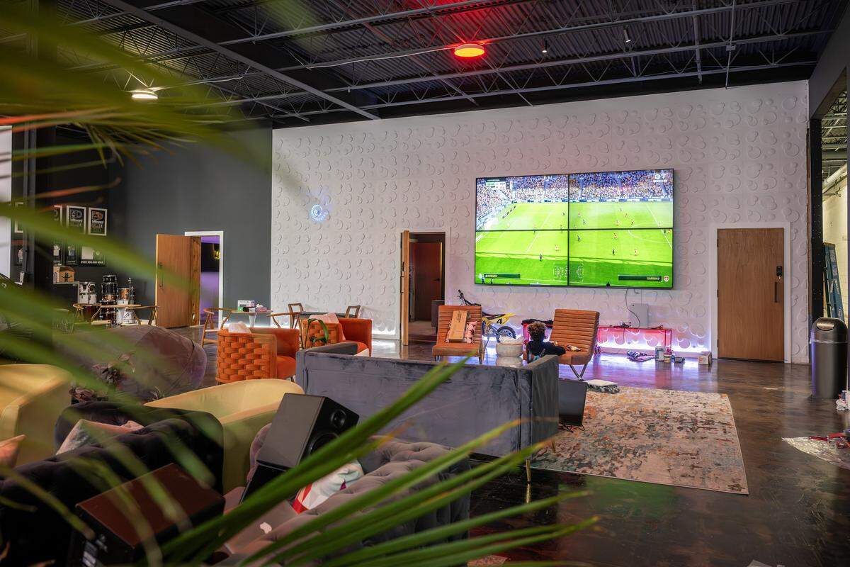 A lounge area with seating and large TV screens is seen in the DISTRKCT space at Agnes Arts on Tuesday, Nov. 25, 2025, in Kansas City.