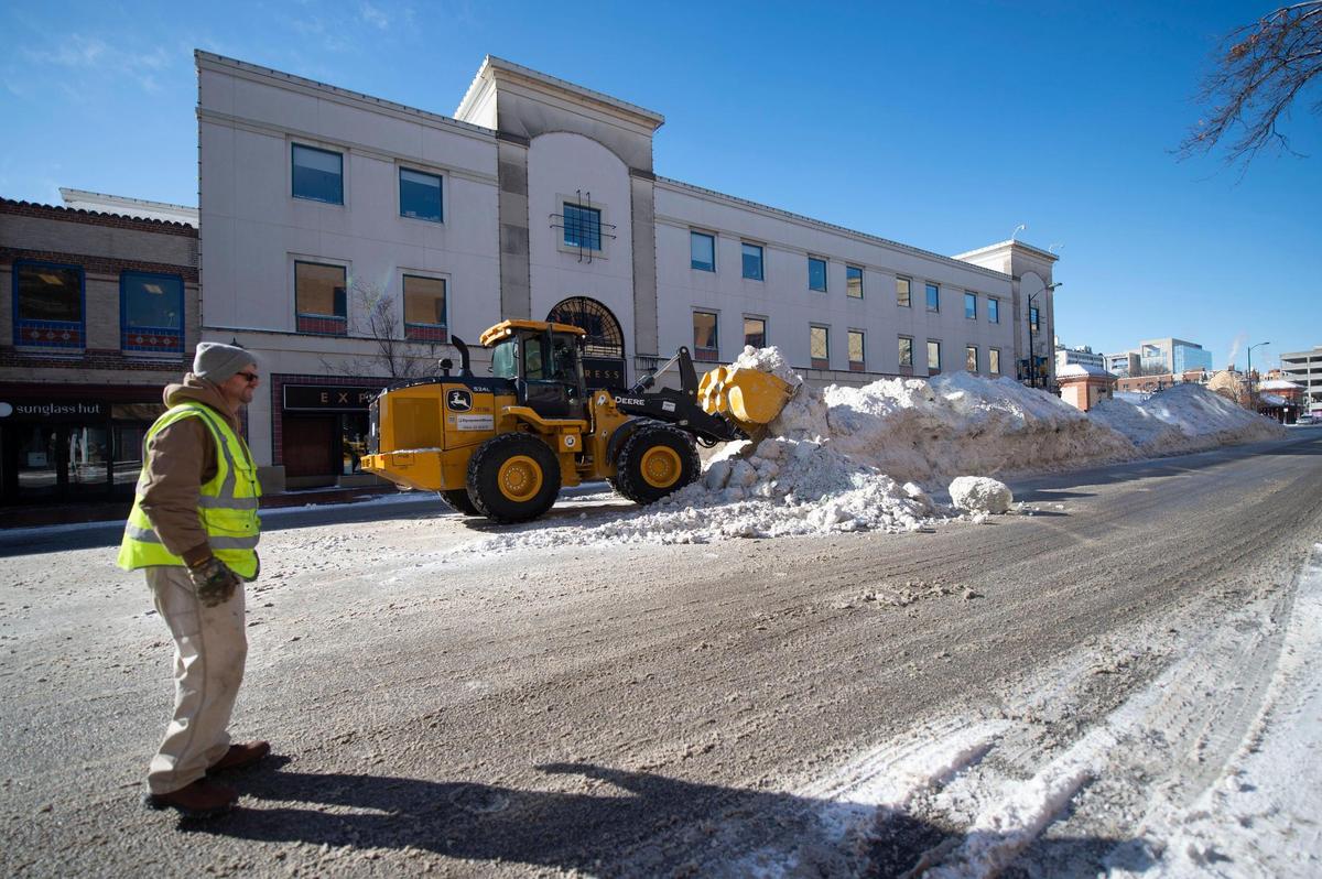 Roy Dillon looked at the snow piled up on Nichols road as he and heavy equipment operator Laurence Salisbury of True North waited for a dump truck to arrive to remove the 10-foot-high pile of snow from the Country Club Plaza on Tuesday, Feb, 16, in Kansas City. Dillon said the sub-zero weather was causing delays in the arrival of the dump trucks.