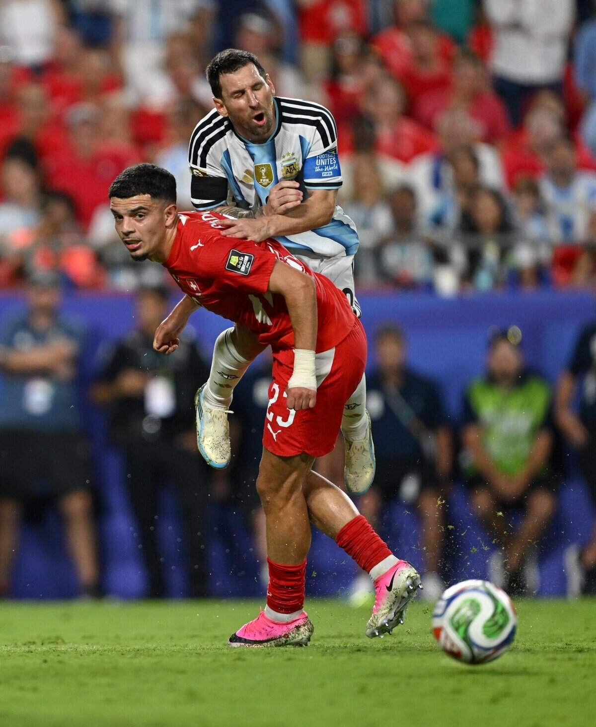 Argentina forward Lionel Messi (10) falls on Switzerland forward Zeki Amdouni (23) in the Argentina vs. Switzerland 2026 World Cup Quarterfinal football match at Kansas City (Arrowhead) Stadium in Kansas City on Saturday, July 11, 2026.