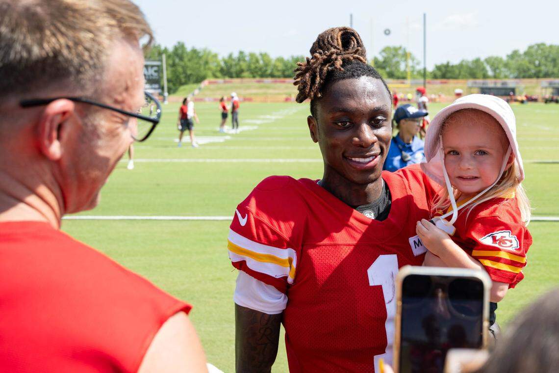 Kansas City Chiefs wide receiver Xavier Worthy (1) holds a fan’s baby and poses for a picture after a 2024 training camp practice in St. Joseph.