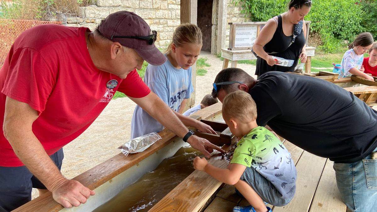 Volunteer Evan James, left, helps out at the mining station. James began volunteering at the Farmstead when he retired in 2019.