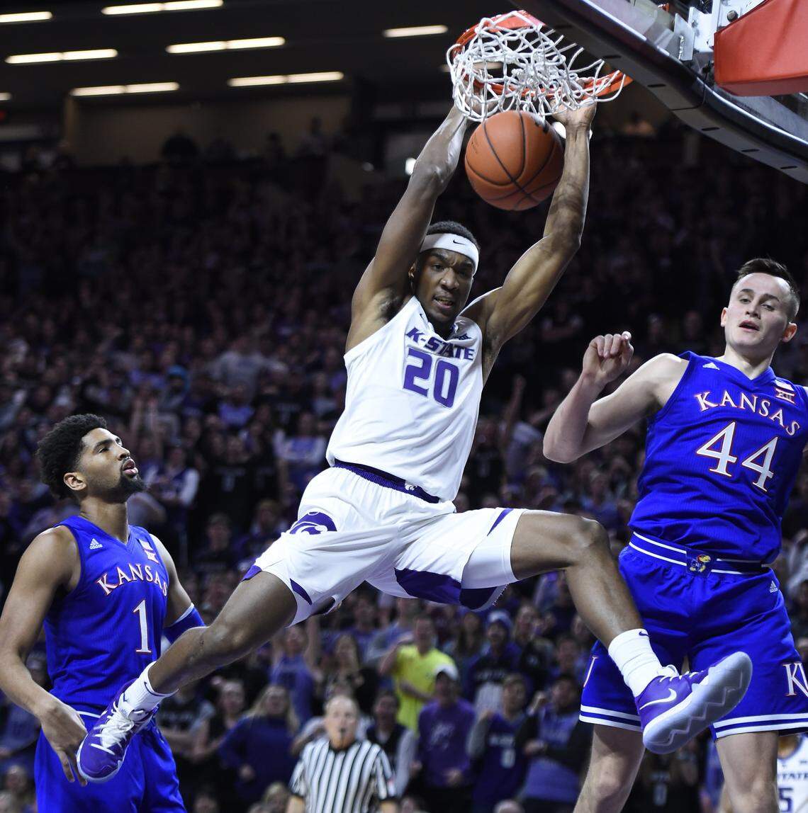 K-State’s Xavier Sneed caught this alley-oop pass for a dunk over Kansas’ Dedric Lawson, left, and Mitch Lightfoot, during the first half of Tuesday night’s game at Bramlage Coliseum.