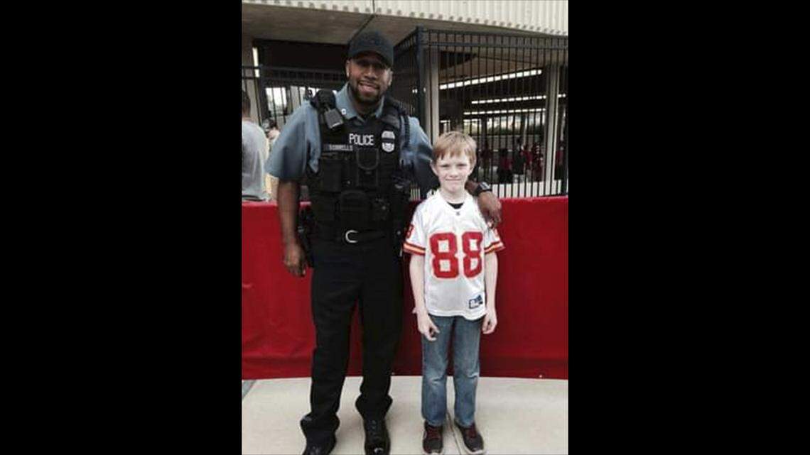 Kevin Sorrells, a former Kansas City police officer, poses for a photo with a child at Arrowhead Stadium. Growing up on the East Side, Sorrells believed he was destined to become a cop.