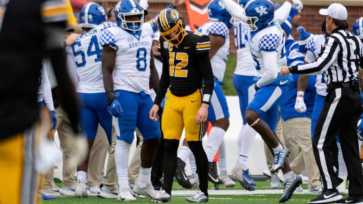 The Kentucky Wildcats celebrate after recovering a fumble by Missouri quarterback Brady Cook, center, during Saturday’s game in Columbia, Mo.