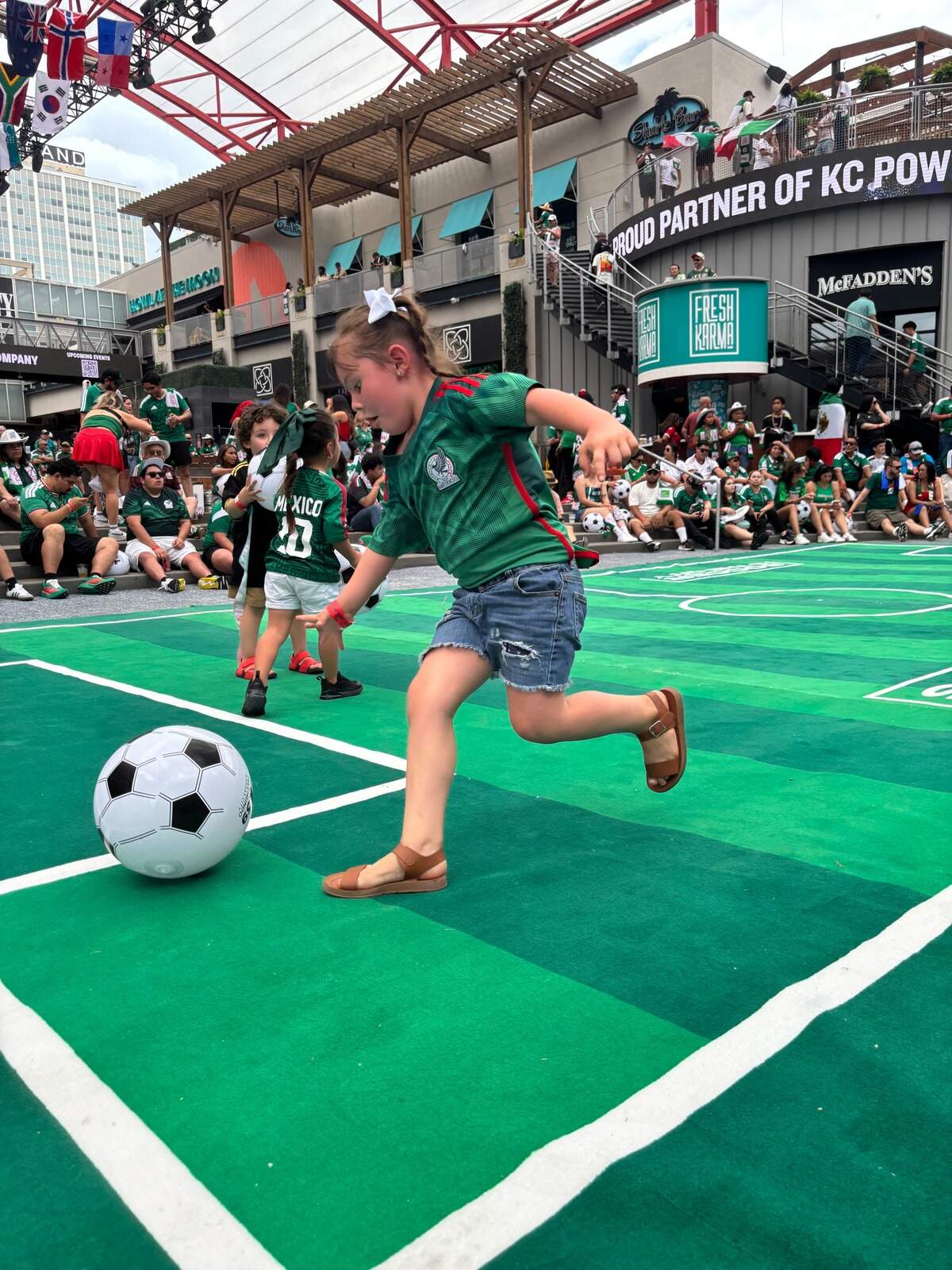 A child chases an inflatable soccer ball at the Power and Light District before the opening match of the 2026 FIFA World Cup. Mexico bested South Africa 2-0. June 11, 2026.