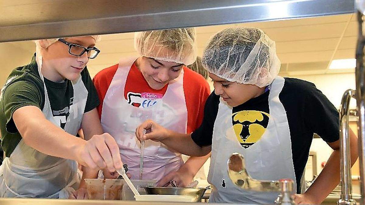 From left: Cooper Johnston and Ethan Gage, eighth-graders at Trailridge Middle School, and Brian Briones Tadlock, a seventh-grader at Mill Creek Middle School, collaborate to create a chewy, crunchy candy bar at Fun with Food Science camp in July at Kansas State University’s Olathe campus. They were among 15 Johnson County middle-school students attending the camp.