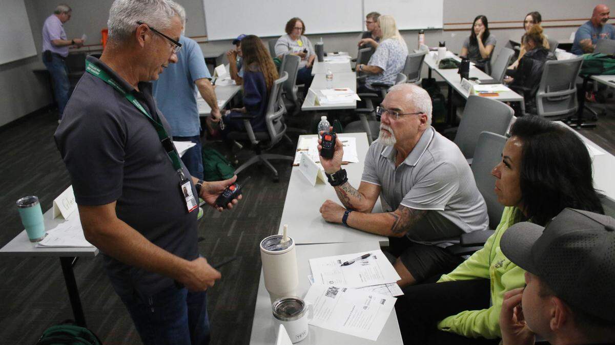 Jeremy Korn gives Randy Martin and Roberta Curtin pointers on how to use a radio for emergency communication during a Community Emergency Response Team training class.