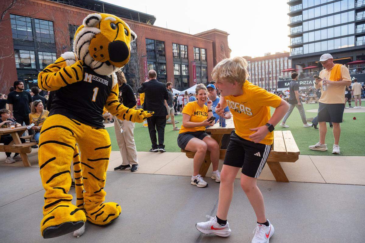 Henry Hohman, 11, dances with Truman the Tiger at the Mizzou Spirit Rally at Ballpark Village on Friday, March 20, 2026, in St. Louis. The Missouri Tigers faced off against the Miami Hurricanes in the first round of the NCAA Men's Basketball Tournament in St. Louis.