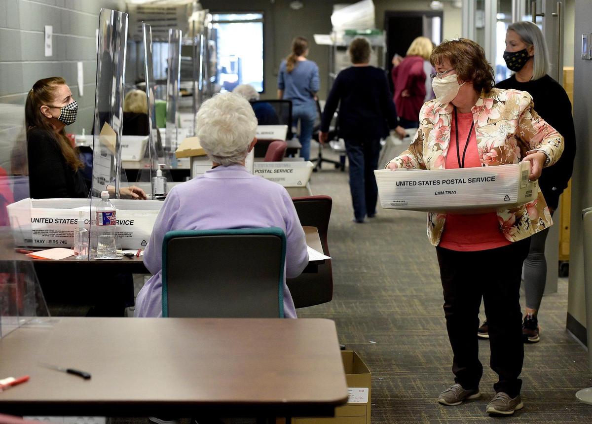 A room full of election workers at the at the Johnson County Election Office in Olathe, including Linda Zody, right, unfolded and prepared thousands of mail-in ballots Thursday, Oct. 29, 2020, for a scanner that will store the ballot images.