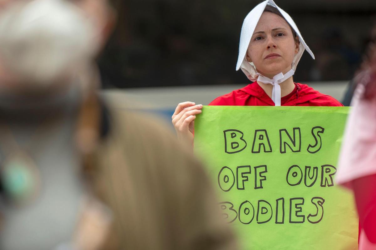 Jennifer Seward dressed as a character from the television show the “Handmaid’s Tale” while protesting on Tuesday, May 3, 2022. Kansas Citians gathered to express opposition to a draft opinion by the U.S. Supreme Court indicating it plans to overturn Roe Vs Wade.