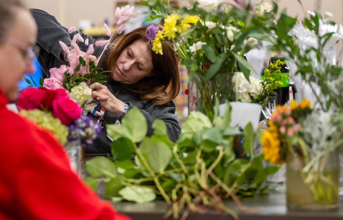 Christy Conkling, left, and Emilee Matzen, floral designers at Toblers Flowers in Kansas City, create a fresh floral arrangements for the Valentine’s Day rush on Thursday.
