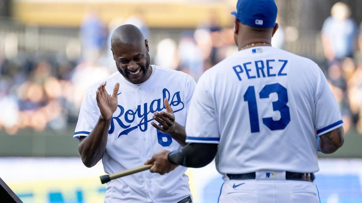 Former Kansas City Royals center fielder Lorenzo Cain laughs as he’s presented with a cane by former teammate Salvador Perez during a retirement ceremony at Kauffman Stadium on Saturday, May 6, 2023, in Kansas City. Cain signed a ceremonial one-day contract to retire as a Royal.