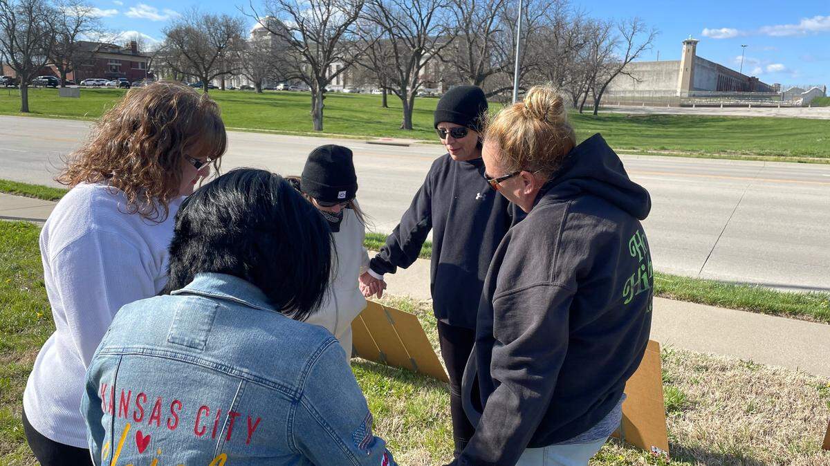 A group prays for their loved ones across the street from the U.S. Penitentiary Leavenworth, which has been on “modified operations” since March 1.