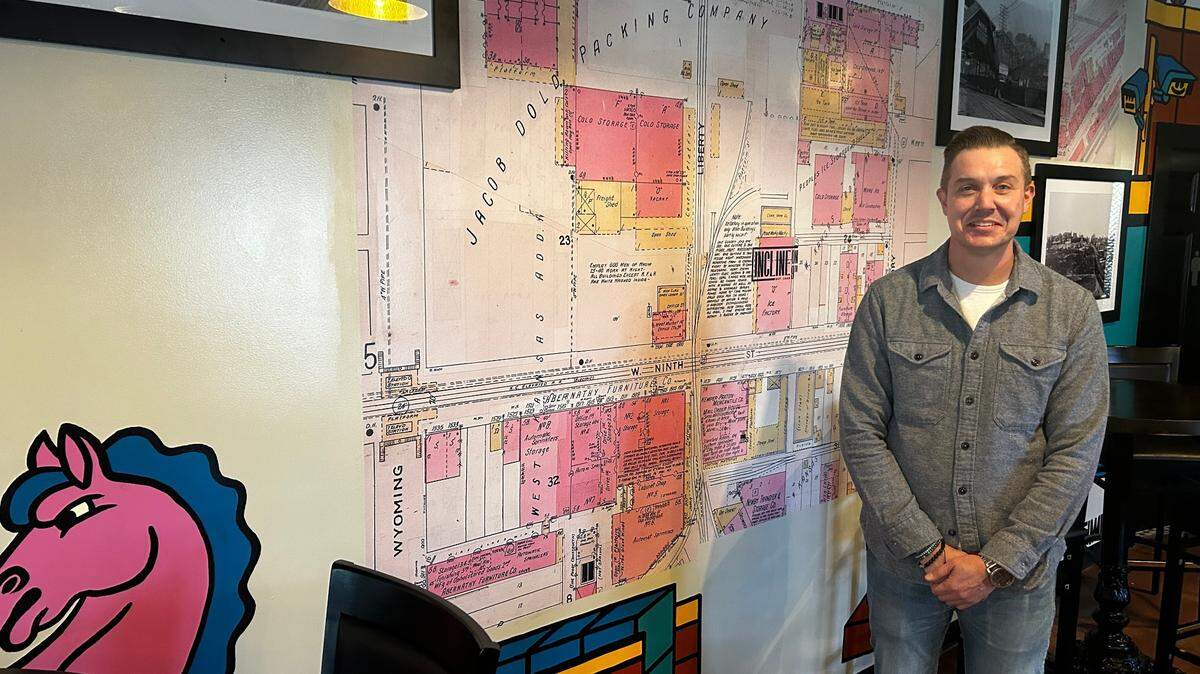 Owner P.J. Purtle shows off a historical wall collage inside Incline on 9th, which opened recently in the West Bottoms.