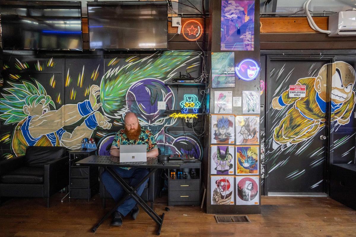 Nicholas Montgomery, social media specialist for Otaku Lounge, works from a table at the lounge.