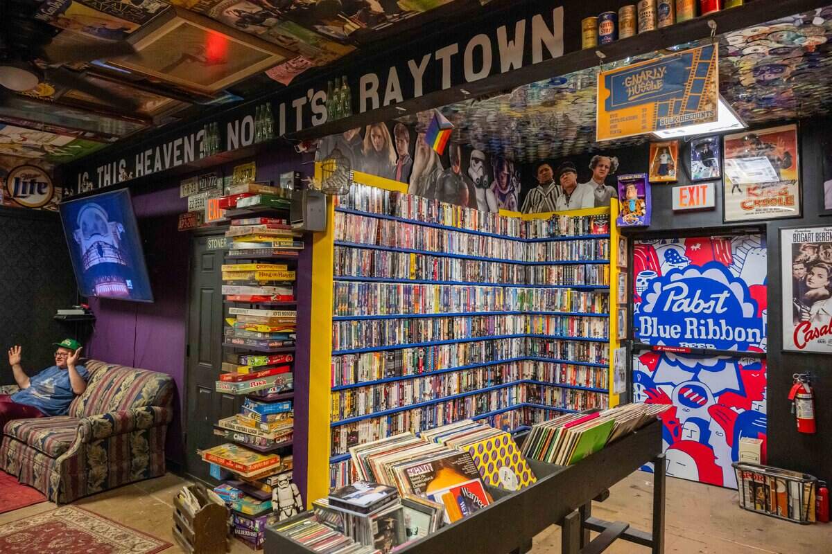 Walls filled with DVD’s, VHS tapes, books, and other vintage physical media inside the bar area of Gnarly Hussle.
