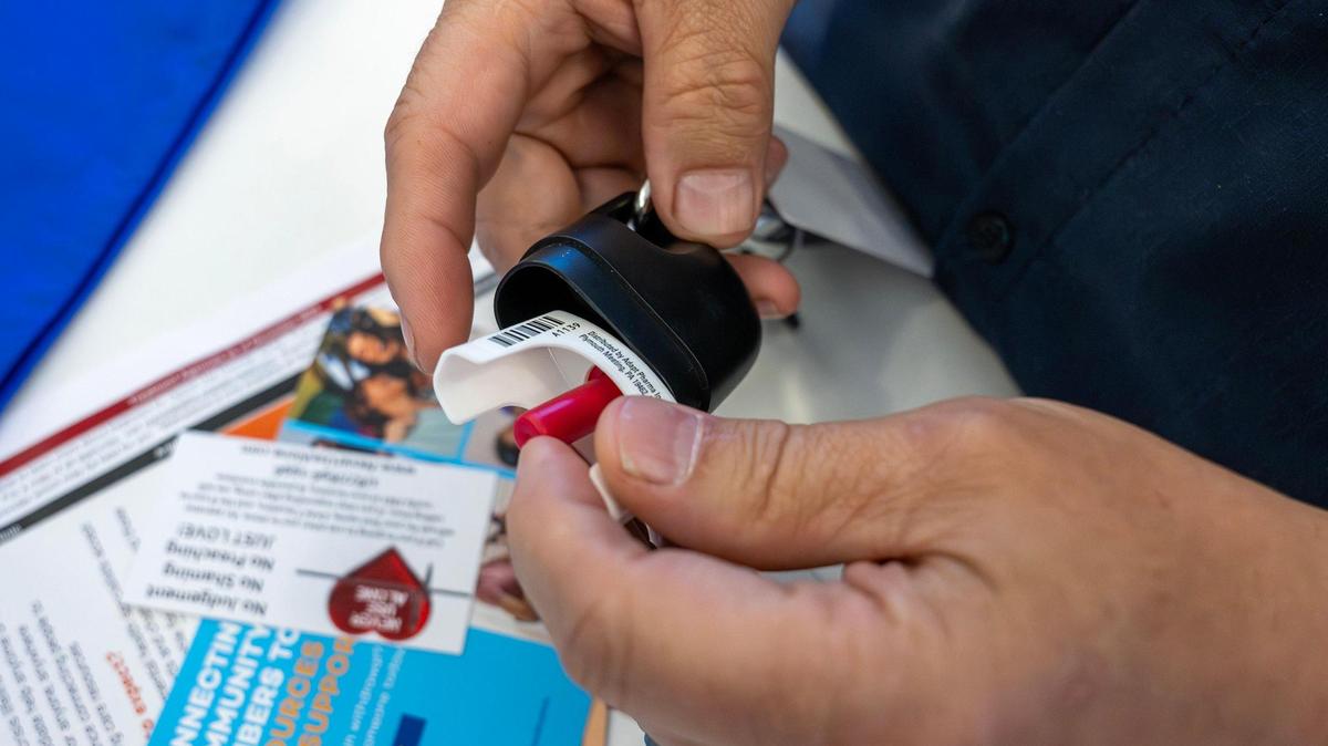 Community Paramedic Matt Cushman of the Raytown Fire Protection District places a nasal spray of Naloxone HCl into a case attached to his keychain on Monday, May 12, 2025, in Kansas City. Naloxone, commonly known by the brand name Narcan, is a medication that can rapidly reverse an opioid overdose and is often carried for emergency use.