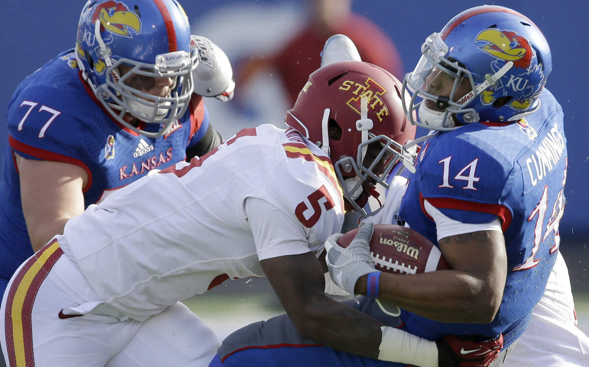 Kansas quarterback Michael Cummings (14) is tackled by Iowa State free stafety Kamari Cotton-Moya (5) during the first half of an NCAA college football game in Lawrence, Kan., Saturday, Nov. 8, 2014. 